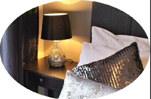 a bedroom with a bed with a lamp on a table at The Rooms at The Spout in Kilcullen