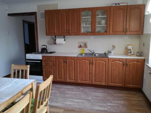 uma cozinha com armários de madeira e uma bancada em Leśniczówka Leśny azyl em Stanisławice