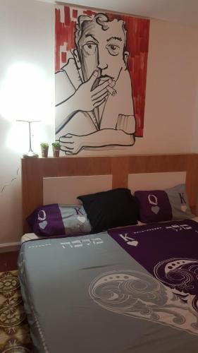 a bedroom with a bed with a painting on the wall at Liraz suits in Rishon LeẔiyyon