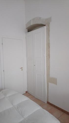 シラクーサにあるL'Acantoの白いドア付きのベッドルーム1室