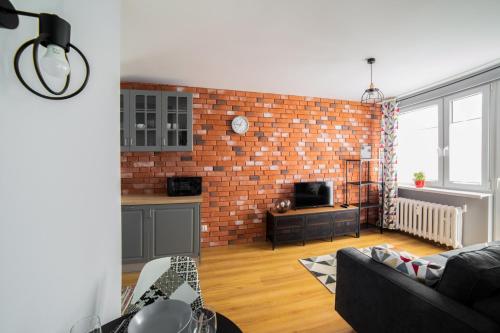 a living room with a brick wall at Apartament Dla Ciebie in Olsztyn