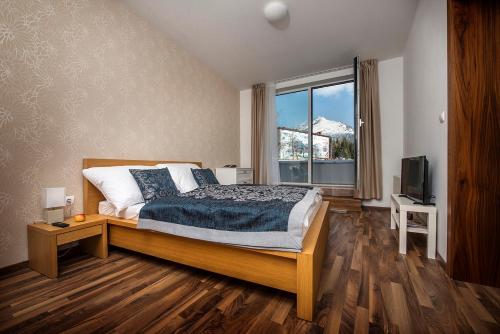 a bedroom with a bed and a large window at Apartment No. 11, Apartment House Oliver in Štrbské Pleso