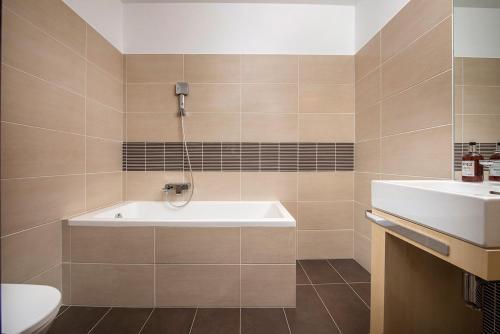 y baño con bañera y lavamanos. en Apartment No. 11, Apartment House Oliver, en Štrbské Pleso