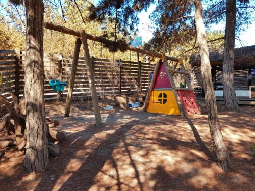 un parque infantil con un columpio en un patio en Cabañas Punta de Lobos, en Pichilemu