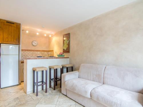 Il comprend un salon avec un canapé et une cuisine. dans l'établissement Apartment Les Carles by Interhome, à Saint-Tropez