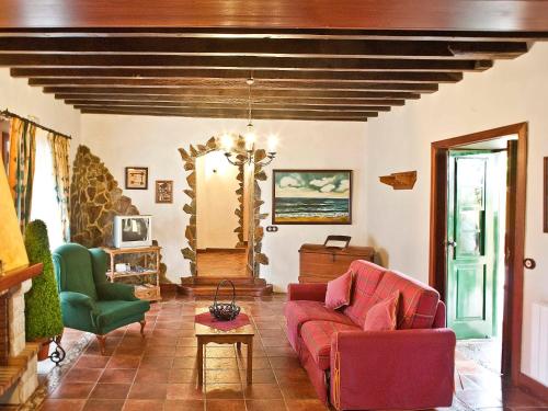 a living room with a red couch and green chairs at Holiday Home Camino La Candelaria-2 by Interhome in La Orotava