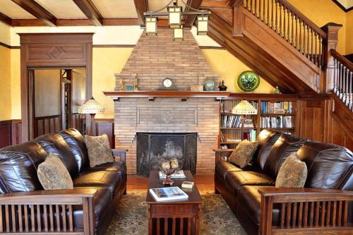 a living room with a leather couch and a fireplace at Iron Horse Inn in Granbury