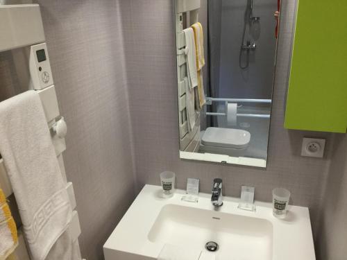 a bathroom with a white sink and a mirror at Hôtel Bellevue Bagnoles Normandie in Bagnoles de l'Orne