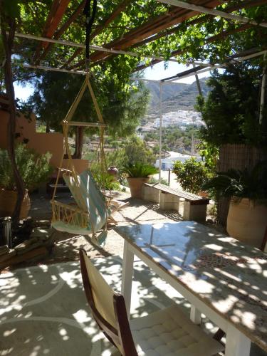 a patio with chairs and a table and a swing at Aperi View in Karpathos Town
