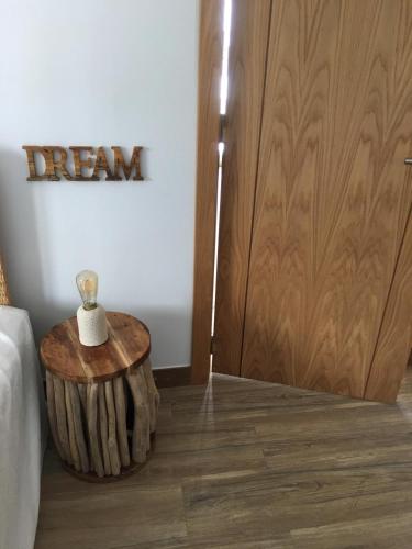 a room with a bed and a wooden table next to a door at Seaside Place Cascais in Carcavelos
