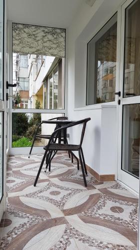 a bench sitting on a porch with a rug at Garsoniera Jad in Tîrgu Ocna