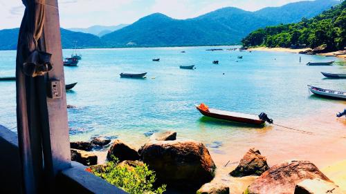 a view of a beach with boats in the water at Pousada Sobre As Ondas de Picinguaba in Picinguaba