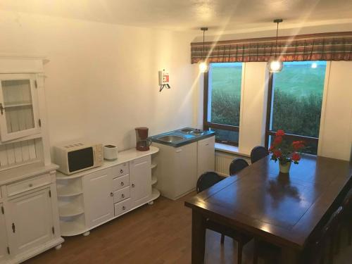 um quarto com uma cozinha com uma mesa e um micro-ondas em Selalækur Country Guesthouse em Hella