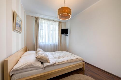 małe łóżko w pokoju z oknem w obiekcie DR Apartments - Patio Mare w mieście Sopot