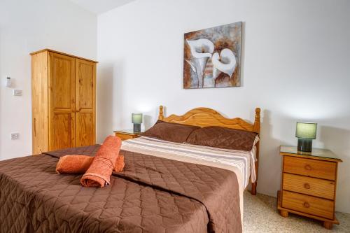 1 dormitorio con 1 cama grande y vestidor de madera en Dolphin Court, en Marsalforn
