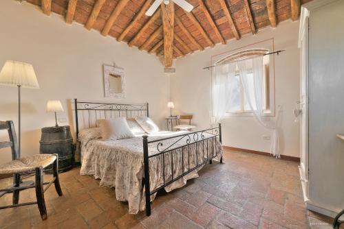 a bedroom with a bed and a chair and a window at Agriturismo La Gioconda in Vinci