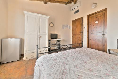 a bedroom with a bed and a tv and a refrigerator at Agriturismo La Gioconda in Vinci