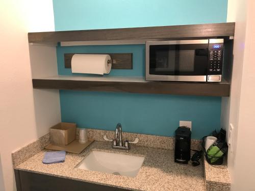 a kitchen counter with a sink and a microwave at Hotel Pensacola in Pensacola