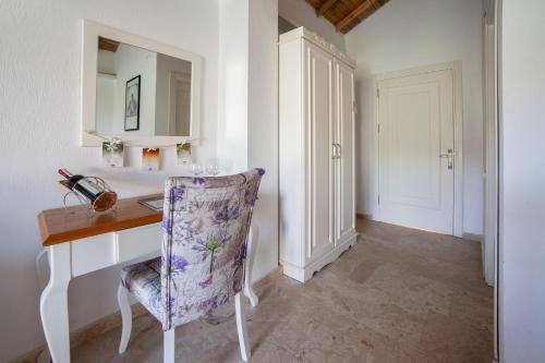 a room with a desk with a chair and a mirror at VINIFERA VINEYARDS HOTEL in Selcuk