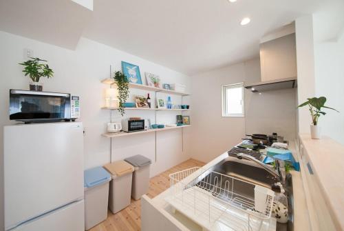 a kitchen with a sink and a refrigerator at 那須塩原にある貸別荘 レンガの家Ｓｏｒａ in Nasushiobara