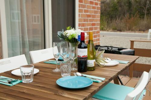 a wooden table with bottles of wine and glasses at 那須塩原にある貸別荘 レンガの家Ｓｏｒａ in Nasushiobara