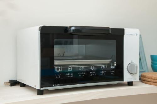 a microwave oven sitting on top of a shelf at 那須塩原にある貸別荘 レンガの家Ｓｏｒａ in Nasushiobara