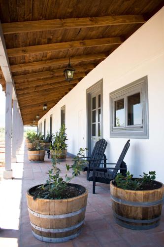 a porch with two chairs and a wooden ceiling at NOI Blend Colchagua in Santa Cruz