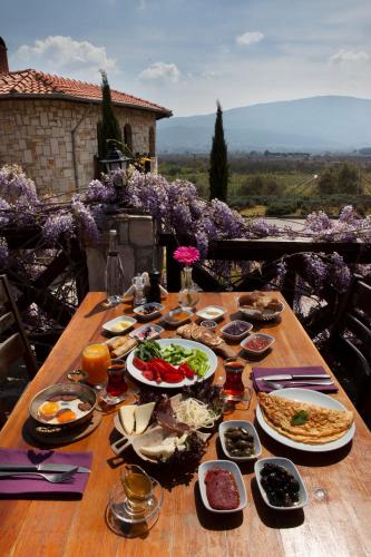 a wooden table with plates of food on it at VINIFERA VINEYARDS HOTEL in Selcuk