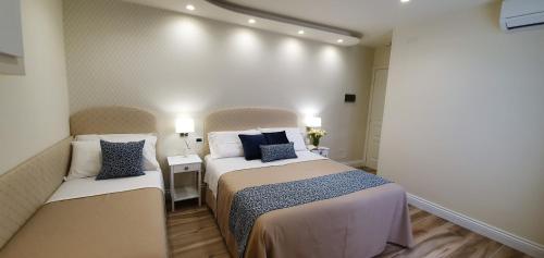 a small room with two beds and two lamps at Ines bed and breakfast in Giardini Naxos