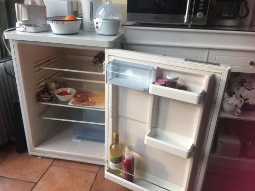 - un réfrigérateur blanc avec une porte ouverte dans la cuisine dans l'établissement Bed and Garden Alde Coninckshof, à Weurt