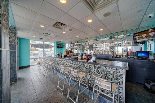 a bar in a restaurant with chairs and a counter at Majestic Beach Towers Resort by Panhandle Getaways in Panama City Beach