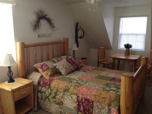 een slaapkamer met een bed, een tafel en een raam bij Bullberry inn Bed & Breakfast in Tropic