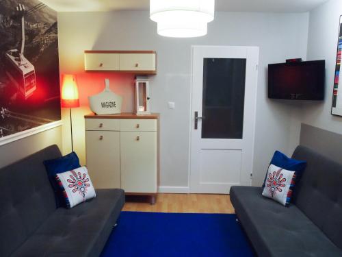 a living room with two couches and a tv at MSC Apartments Gościnny in Zakopane