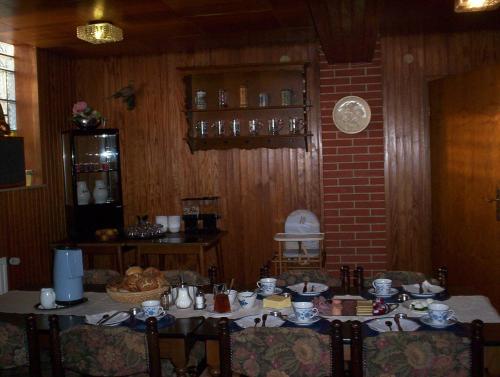 a dining room with a table with dishes on it at Pension Im Rehwinkel in Soltau