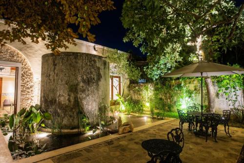 a garden with an umbrella and tables and chairs at Verde Morada in Valladolid