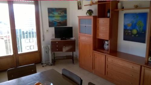 Apartamento Espert في إل بيريلو: غرفة معيشة مع طاولة طعام وتلفزيون