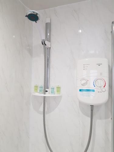 a shower in a white bathroom with a shower at Carnegie Place in East Kilbride