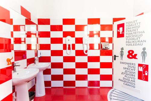 a bathroom with a red and white checkered wall at B13 Hostel in Sibiu
