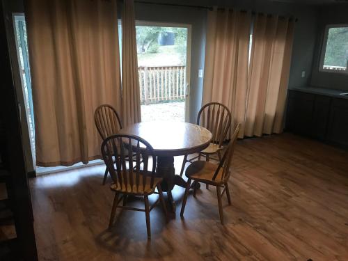 a dining room with a table and chairs and a window at Mountain Trail Lodge and Vacation Rentals in Oakhurst