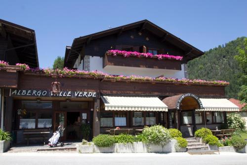 a building with flowers on the side of it at Hotel Valle Verde - Rent Ski & Bike in Tarvisio