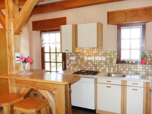 フエナンにあるHoliday Home Maison Mestrezec by Interhomeの白いキャビネットと木製テーブル付きのキッチン