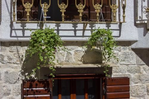 a balcony with two potted plants on a building at Palace Derossi in Trogir