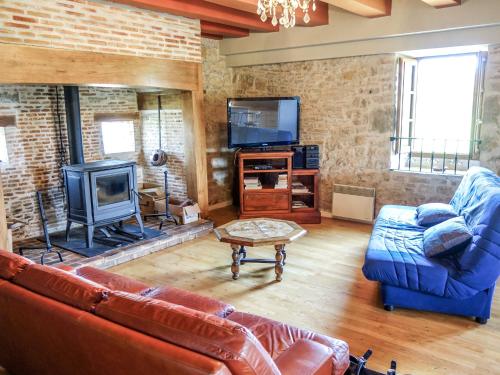 a living room with a couch and a tv at Holiday Home Sourdoire by Interhome in La Chapelle-aux-Saints