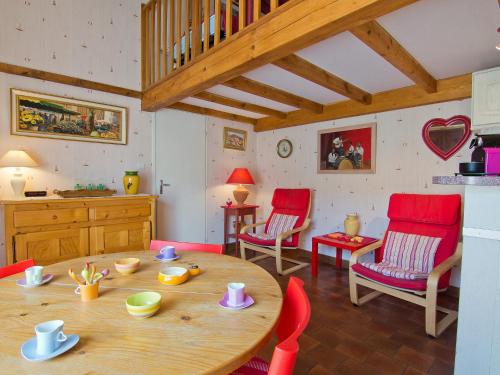キャヴァレール・シュル・メールにあるHoliday Home Le Clos du Rigaud-1 by Interhomeのリビングルーム(木製テーブル、赤い椅子付)