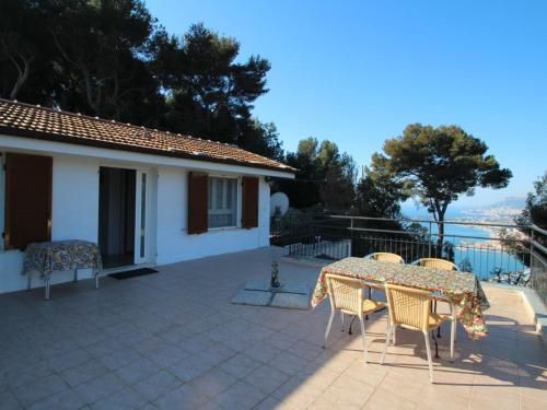 a patio with a table and chairs in front of a house at Apartment Taverna Il Cippo by Interhome in Mortola Superiore