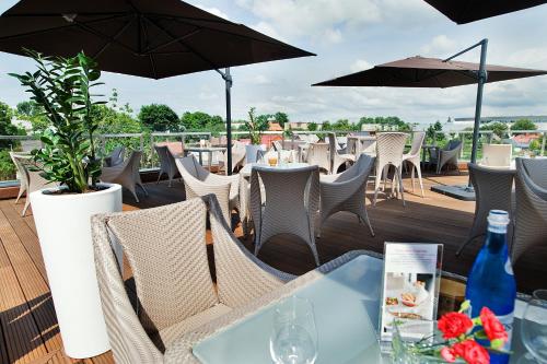 a patio with tables and chairs and umbrellas at Hotel Great Polonia Velvet Suwałki in Suwałki