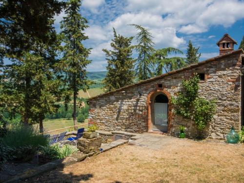 een stenen gebouw met een deur in een tuin bij Holiday Home Le Bonatte-3 by Interhome in Radda in Chianti