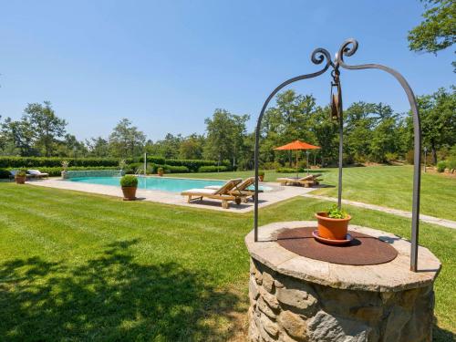 una fuente de piedra en un patio con piscina en Holiday Home Tenuta Farneta by Interhome, en Lucignano