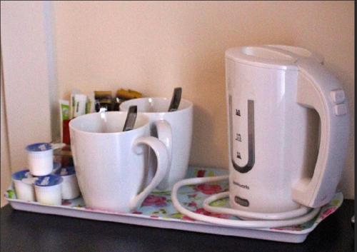 un vassoio con tre tazze di caffè su un bancone di The Rooms at The Spout a Kilcullen