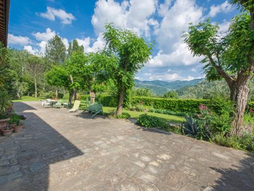 a patio with chairs and trees and mountains in the background at Apartment I Noccioli by Interhome in Rufina